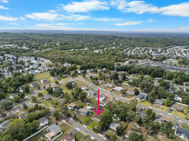 an aerial view of residential houses with outdoor space and lake view