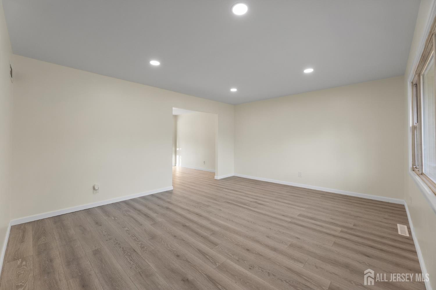 41 Raleigh Road Kendall Park, NJ 08824 - Photo 8 of 40 an empty room with wooden floor and windows