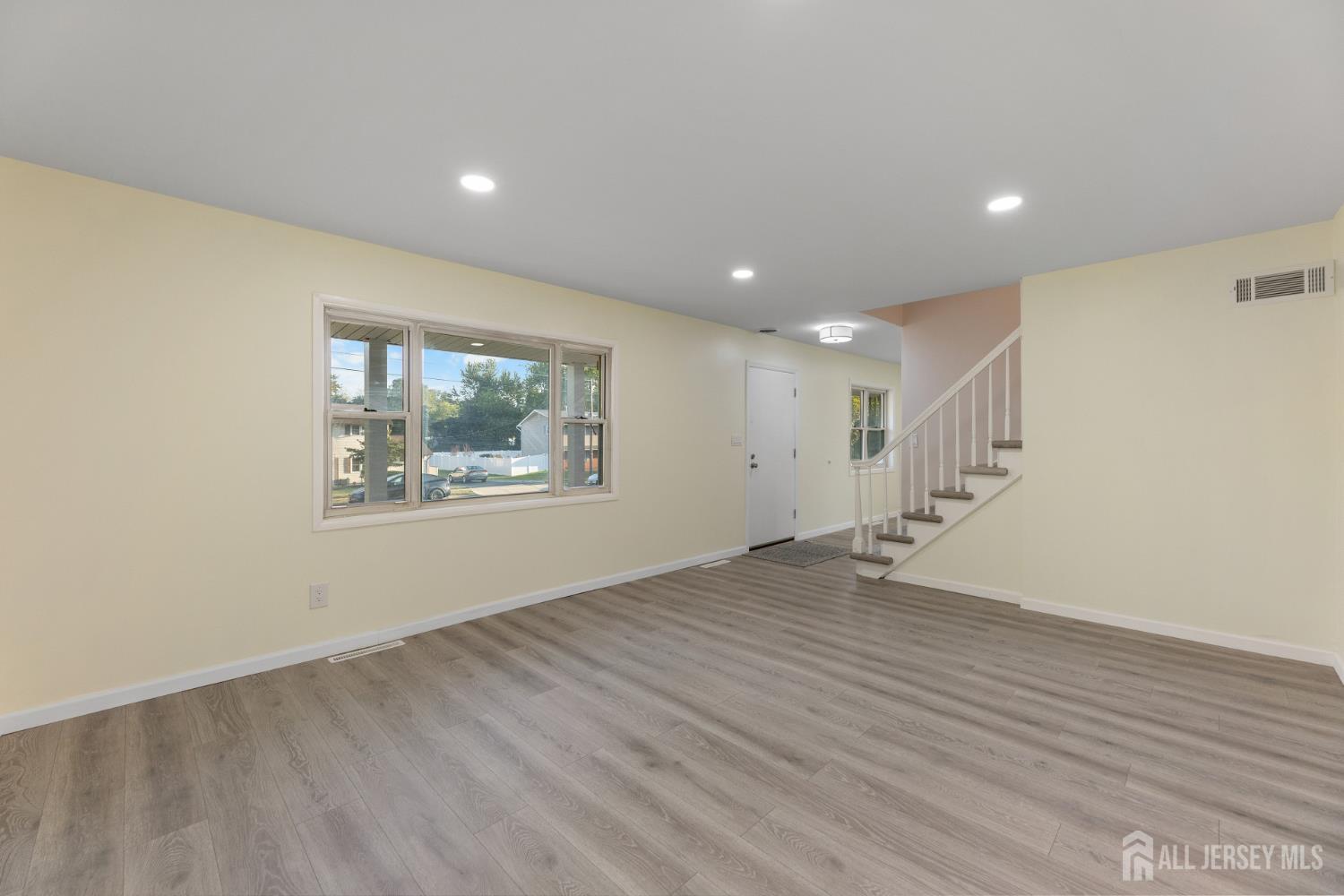 41 Raleigh Road Kendall Park, NJ 08824 - Photo 9 of 40 a view of an empty room with wooden floor and a window