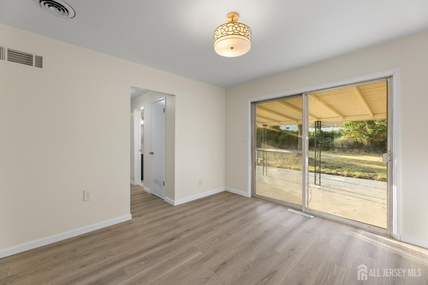 41 Raleigh Road Kendall Park, NJ 08824 - Photo 10 of 40 a view of an empty room with a window and wooden floor