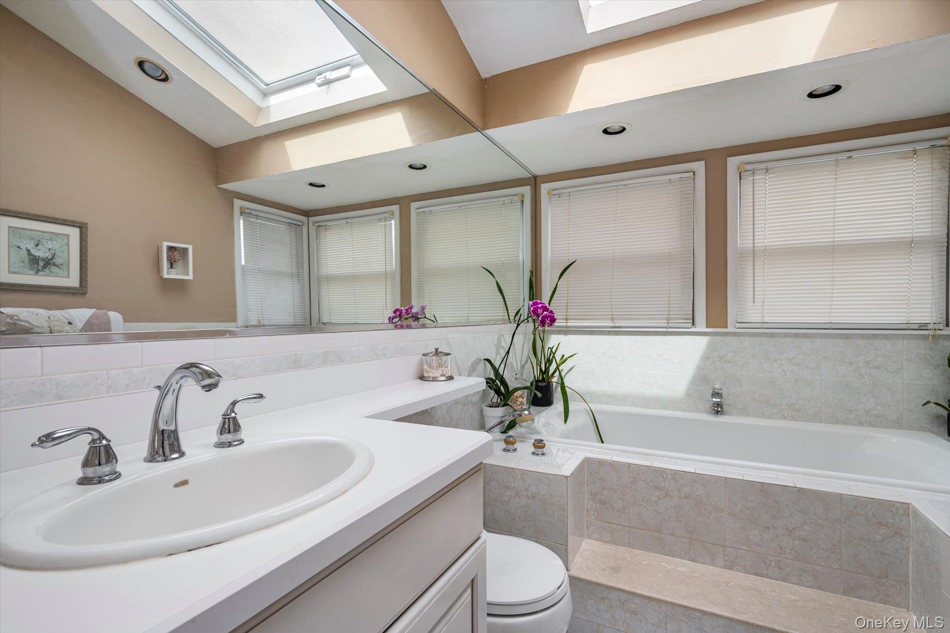 60 Ridge Drive Plainview, NY 11803 - Photo 18 of 27 a bathroom with a granite countertop sink mirror vanity and bathtub