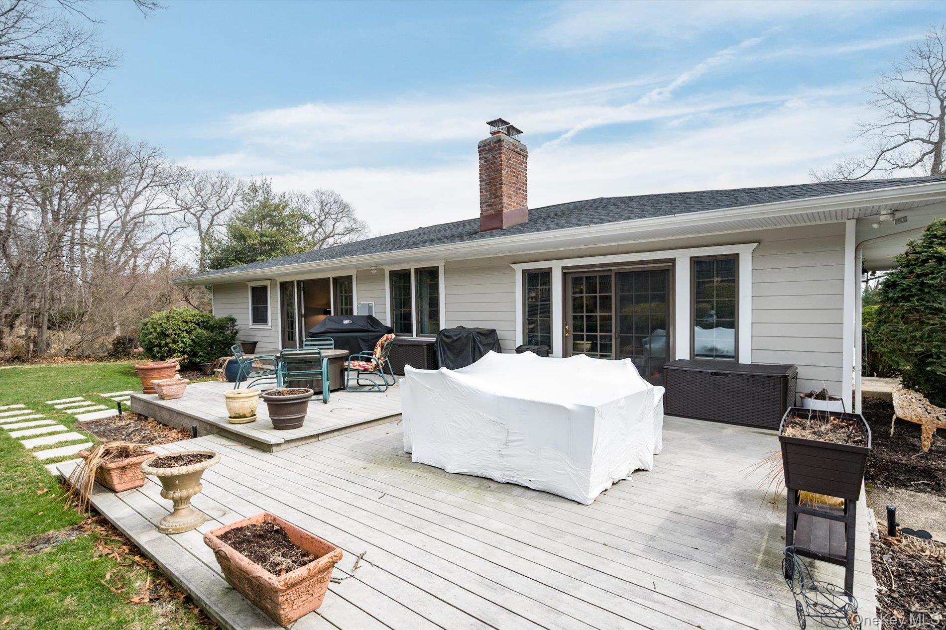 60 Ridge Drive Plainview, NY 11803 - Photo 21 of 27 a view of a patio with couches table and chairs with wooden floor and fence