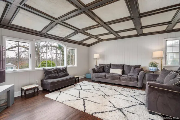 a living room with furniture and a flat screen tv with wooden floor