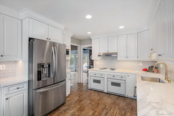 a kitchen with stainless steel appliances a refrigerator sink and wooden cabinets