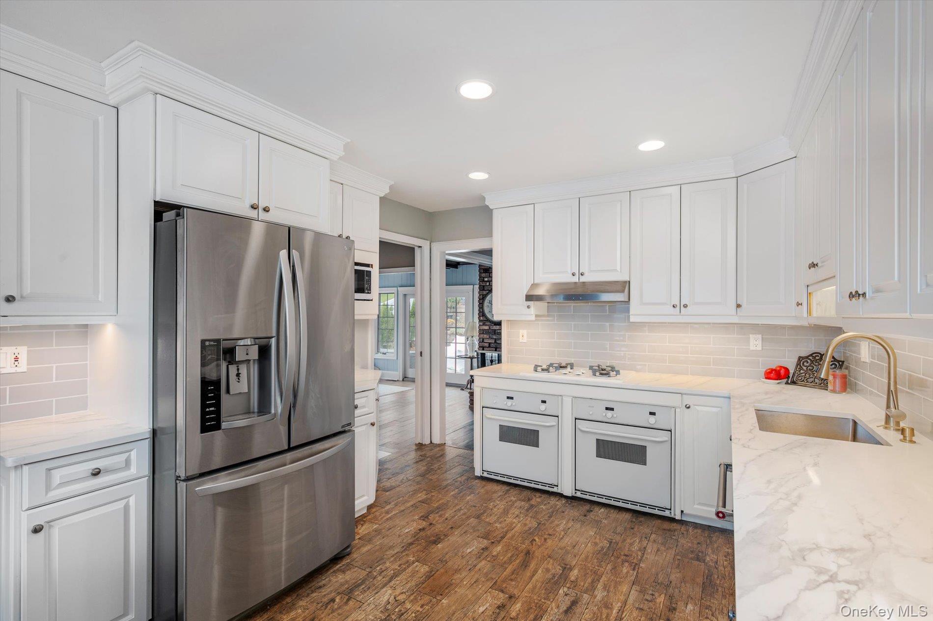 60 Ridge Drive Plainview, NY 11803 - Photo 6 of 27 a kitchen with stainless steel appliances a refrigerator sink and wooden cabinets
