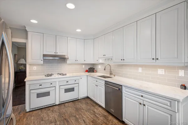 a kitchen with white cabinets and white appliances