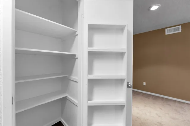 an empty room with windows and fireplace