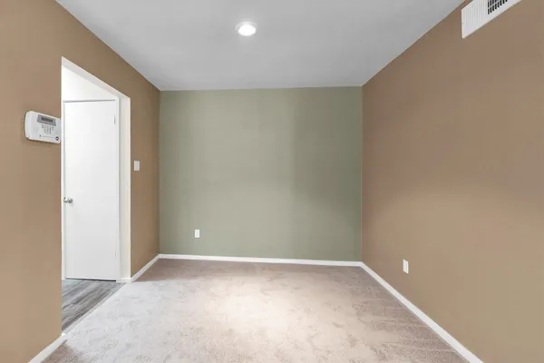 an empty room with windows fire place and a fireplace