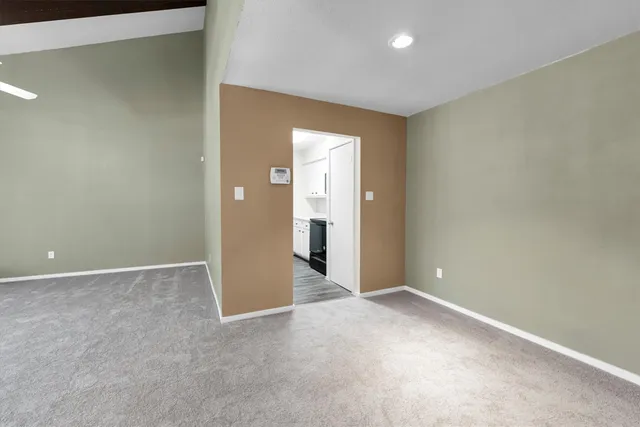 an empty room with windows fire place and a fireplace