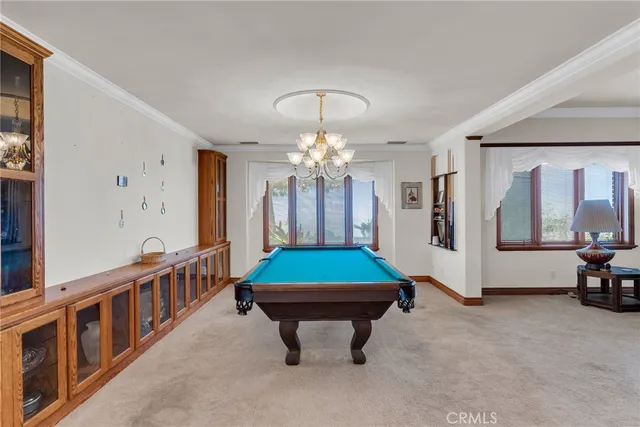 a room with pool table and windows