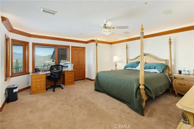 a large bedroom with a large bed a flat tv screen and dresser
