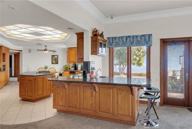 a view of a kitchen with kitchen island stainless steel appliances wooden floor and furniture