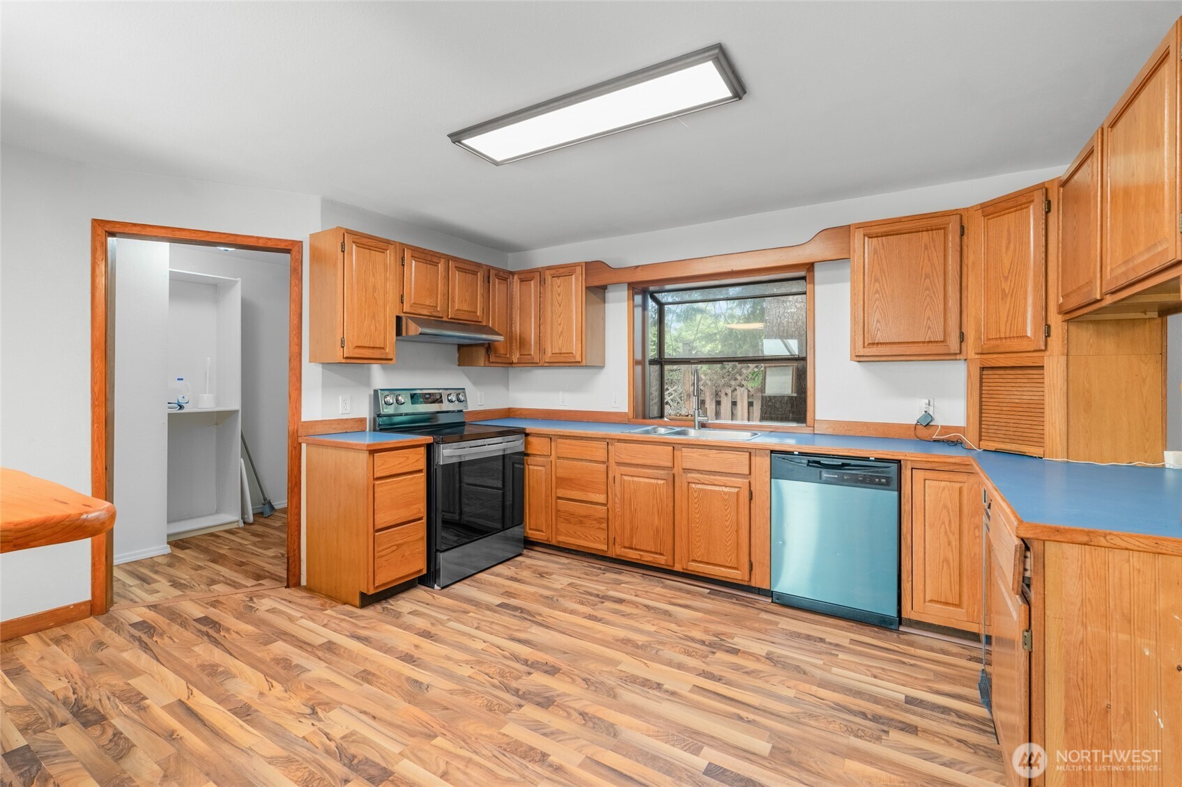 230 East Stavis Road Shelton, WA 98584 - Photo 6 of 35 a kitchen with granite countertop wooden floors a stove a sink and a window
