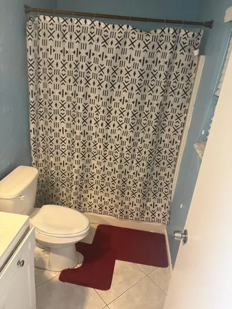 a bathroom with a toilet and a shower curtain