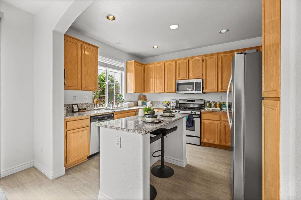 2935 Cliff Circle Carlsbad, CA 92010 - Photo 5 of 17 a kitchen with stainless steel appliances granite countertop a stove a sink dishwasher a refrigerator and a microwave oven with wooden floor
