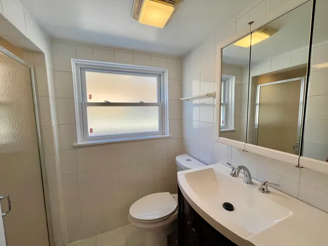 a bathroom with a sink mirror and toilet
