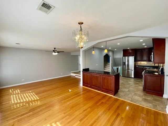a large kitchen with cabinets a sink and a wooden floor