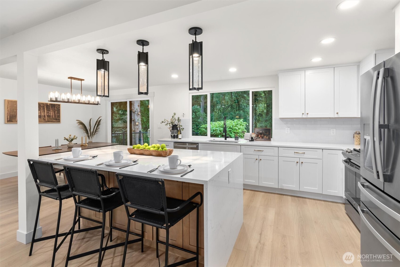 22929 38th Avenue Southeast Bothell, WA 98021 - Photo 5 of 37 a kitchen with stainless steel appliances kitchen island granite countertop a table chairs sink and cabinets