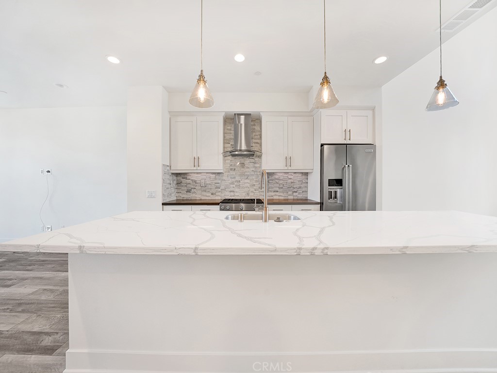 1658 Topanga Costa Mesa, CA 92627 - Photo 8 of 32 a large kitchen with kitchen island a large counter top a sink stainless steel appliances and cabinets