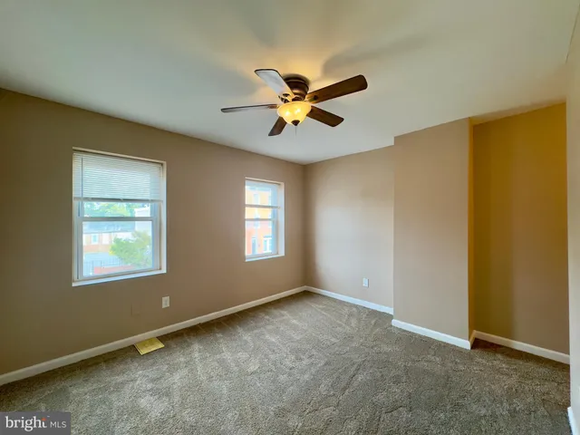 a view of a hallway with wooden floor and windows