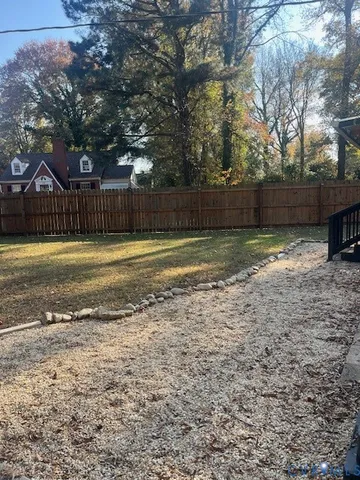 a view of a yard with wooden fence