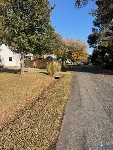 a view of a yard with wooden fence