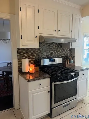 a kitchen with granite countertop white cabinets and stainless steel appliances