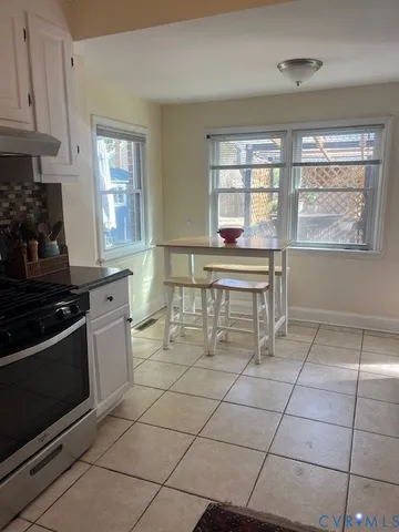 a kitchen with granite countertop a stove a sink and a refrigerator