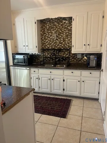 a kitchen with granite countertop white cabinets and sink