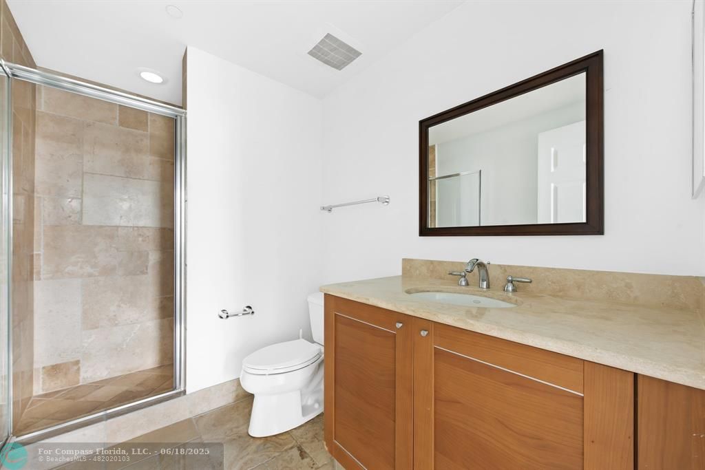 1819 Southeast 17th Street, Unit 803 Fort Lauderdale, FL 33316 - Photo 12 of 20 a bathroom with a toilet sink a mirror and shower