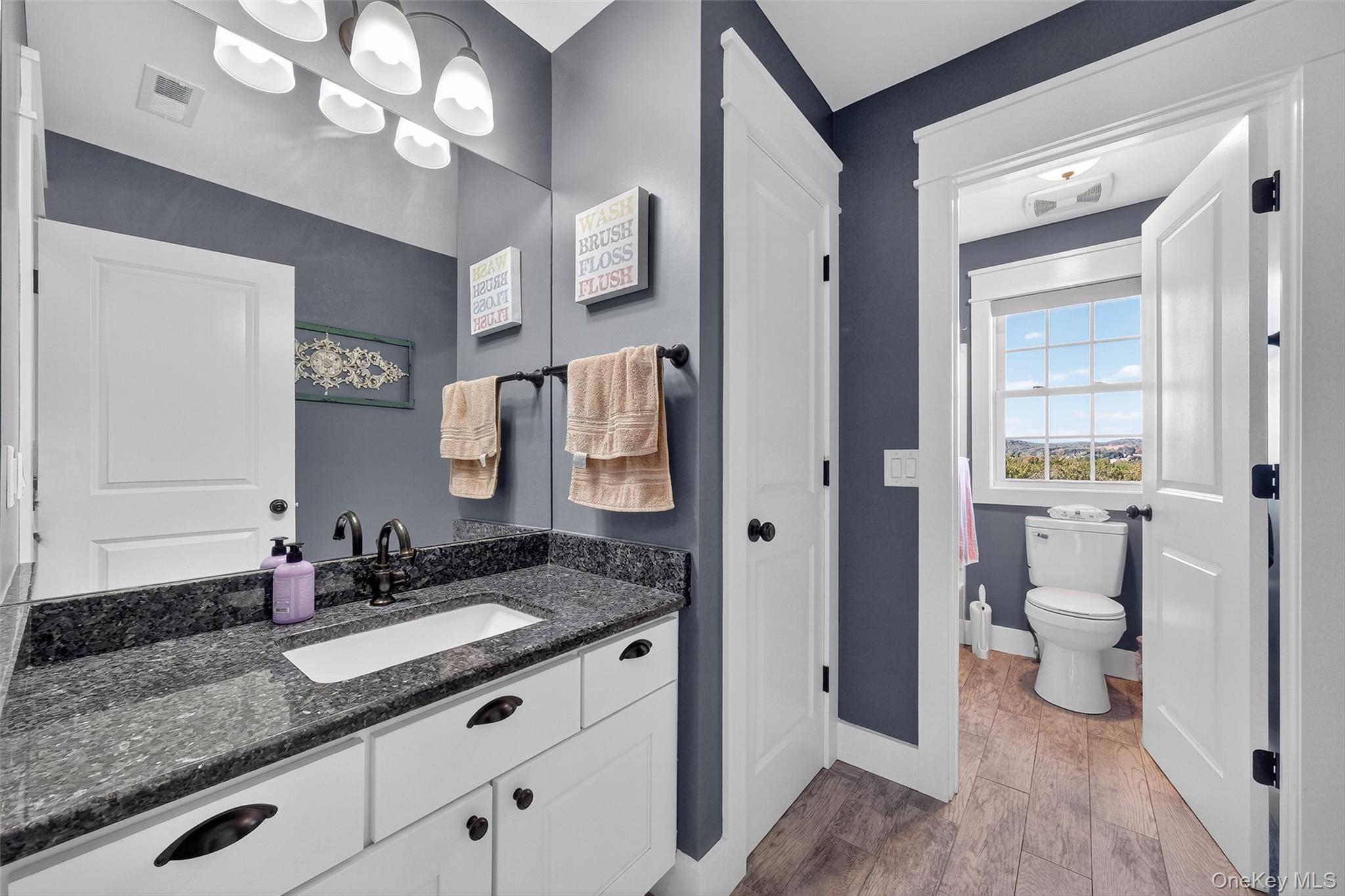 10 Domingues Road Newburgh, NY 12550 - Photo 11 of 30 White vanity with dark stone-finish countertop, undermount sink, and black hardware