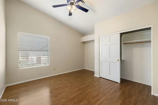 a view of an empty room with a window and wooden floor