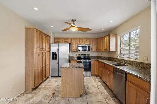 a kitchen with stainless steel appliances granite countertop a refrigerator and a stove top oven
