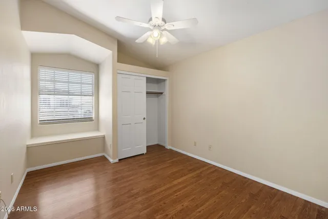 an empty room with windows and fan
