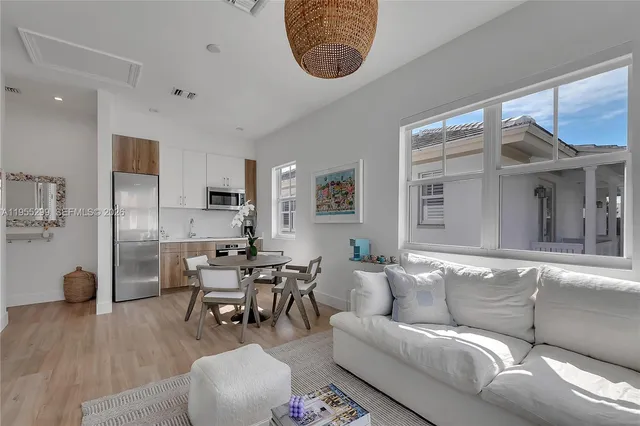 a living room with furniture a wooden floor and a large window