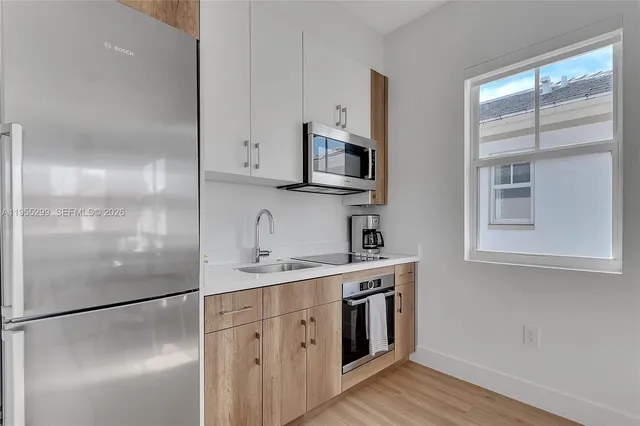 a kitchen with stainless steel appliances a refrigerator sink and microwave