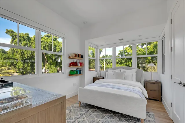 a bedroom with a bed and large windows