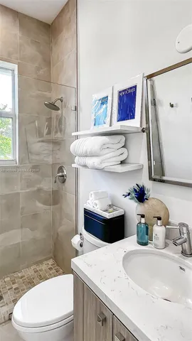 a bathroom with a sink a toilet and shower