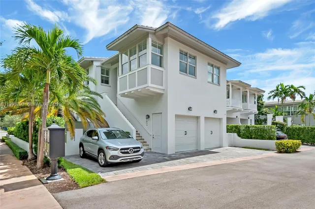 a car parked in front of a white house