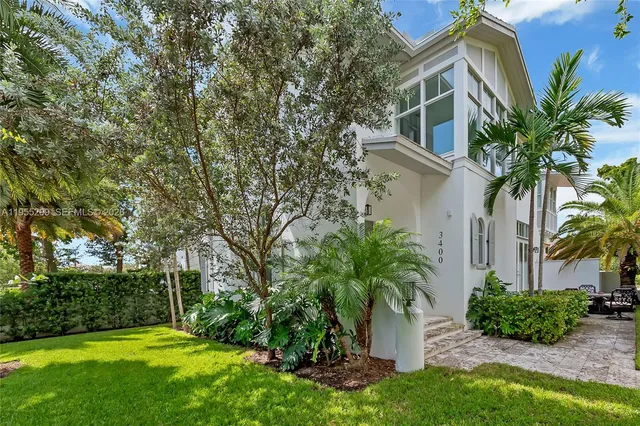 a front view of a house with a yard and potted plants