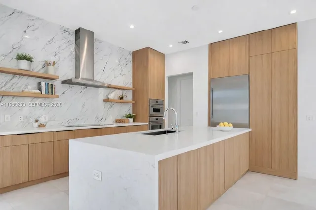 a kitchen with stainless steel appliances a sink and a refrigerator