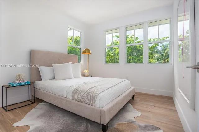 a large bed sitting in a bedroom next to a window