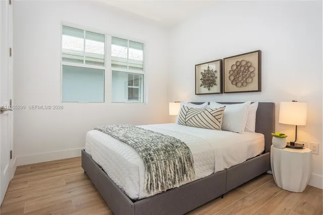 a large bed sitting in a bedroom next to a window