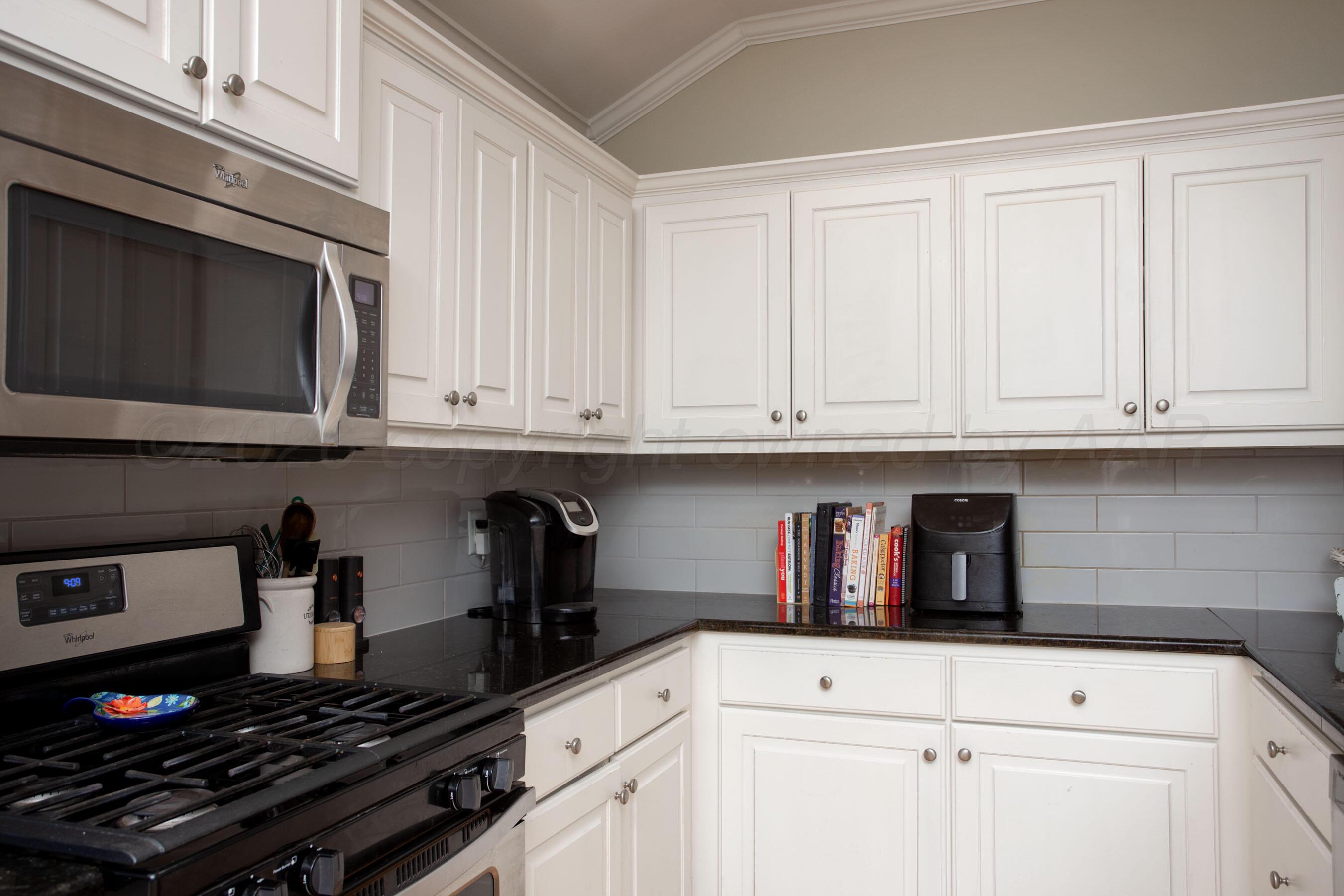 9505 Perry Avenue Amarillo, TX 79119 - Photo 9 of 21 a kitchen with white cabinets and appliances