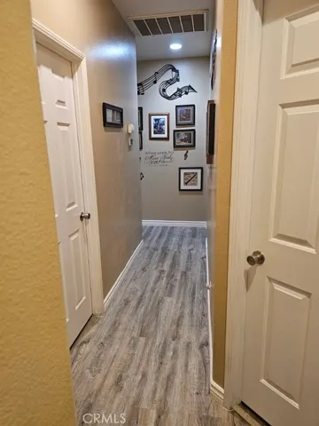 a view of a hallway with wooden floor