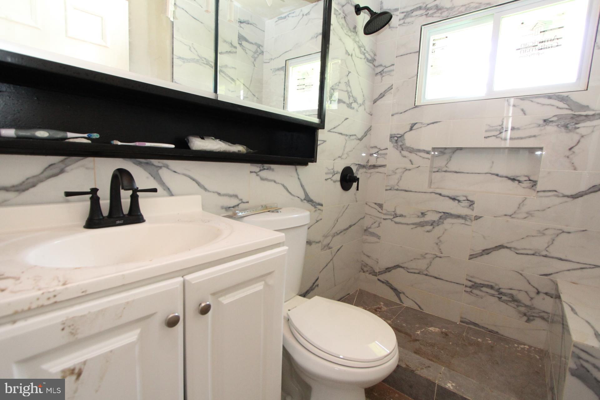 41 Jewel Lane Levittown, PA 19055 - Photo 13 of 24 a bathroom with a sink a toilet and a window