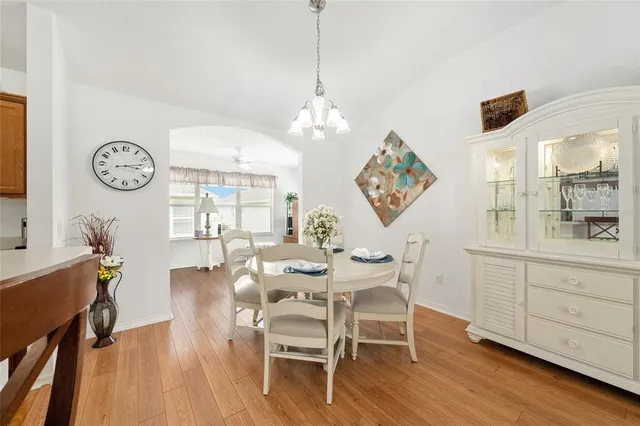 a view of a dining room with furniture a chandelier and wooden floor