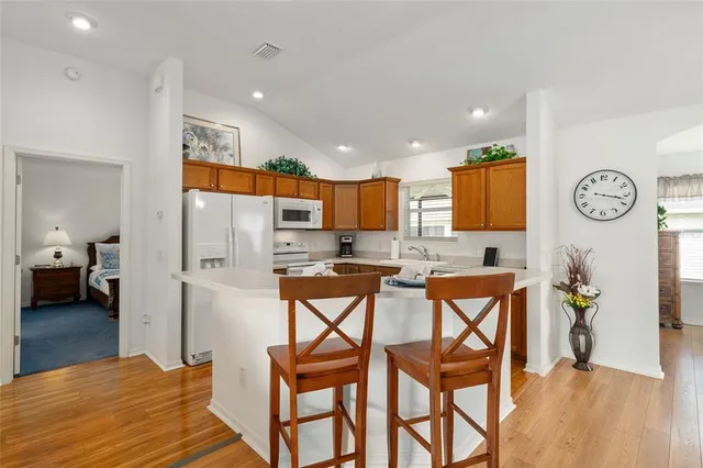 a kitchen with stainless steel appliances kitchen island granite countertop a refrigerator and microwave