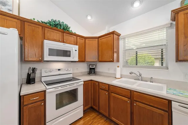 a kitchen with stainless steel appliances granite countertop white cabinets a sink and a microwave