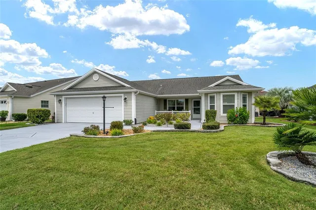 a front view of a house with a garden and trees